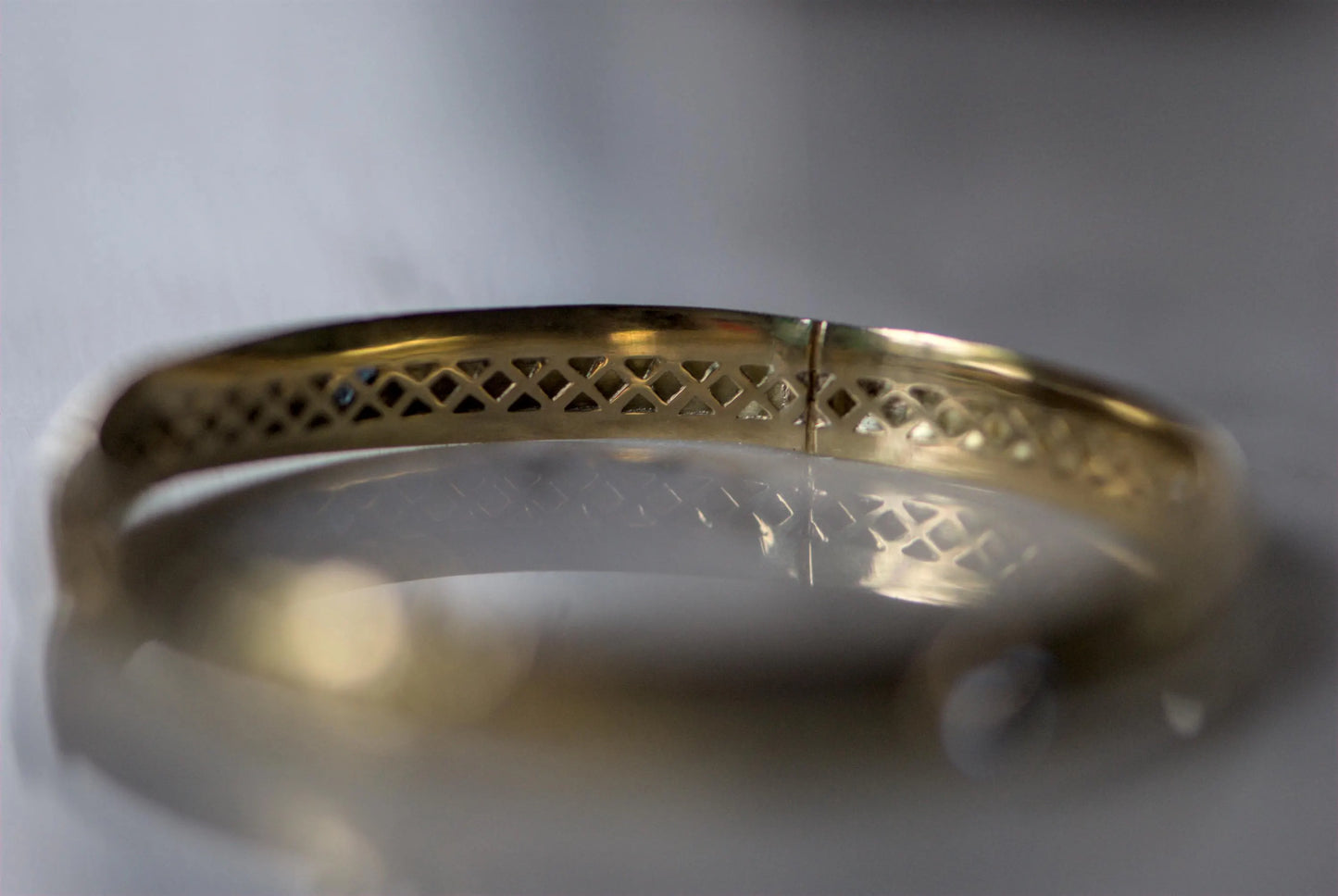 Bracelet ancien jonc rigide ouvrant en or jaune 18K, motifs floraux ciselés en or gris 18k et saphirs bleus