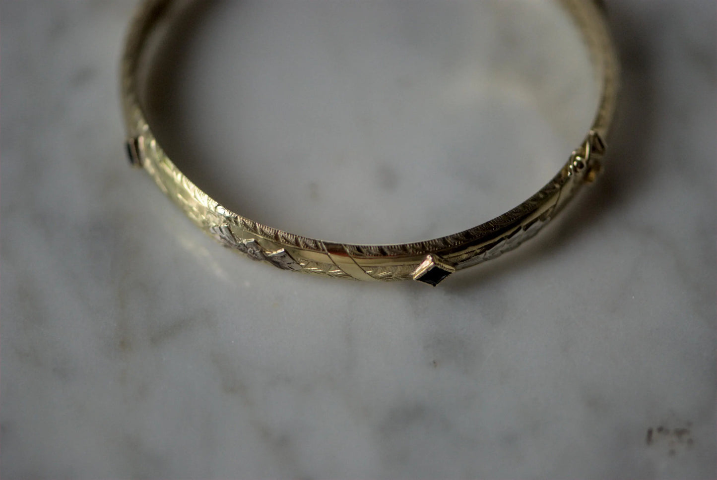Bracelet ancien jonc rigide ouvrant en or jaune 18K, motifs floraux ciselés en or gris 18k et saphirs bleus